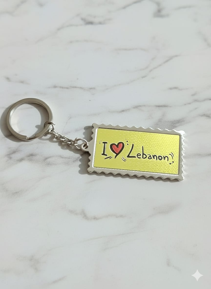 Keychain with 'I ❤️ Lebanon' text on a yellow background against a marble background