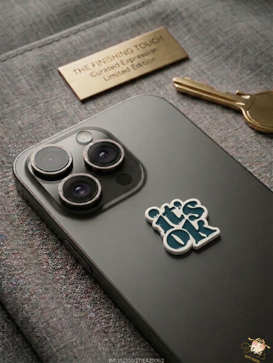 Phone case with 'it's OK' sticker on a textured surface with a key and nameplate.