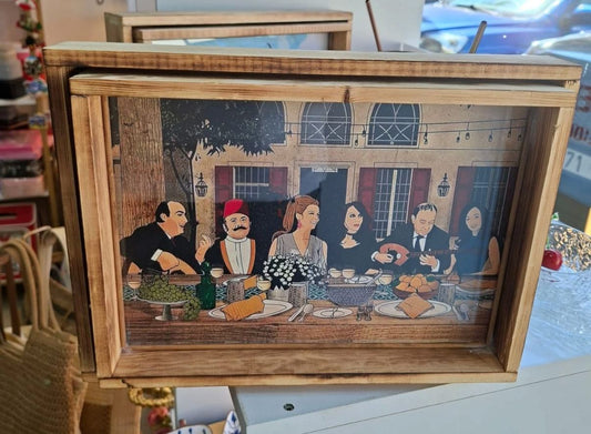 Wooden tray with a decorative scene of people at a table, possibly in a restaurant setting.