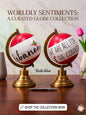 Bold red and white decorative globe featuring the Lebanese flag and 'We are all for the country' typography, resting on a heavy brass and copper stand.