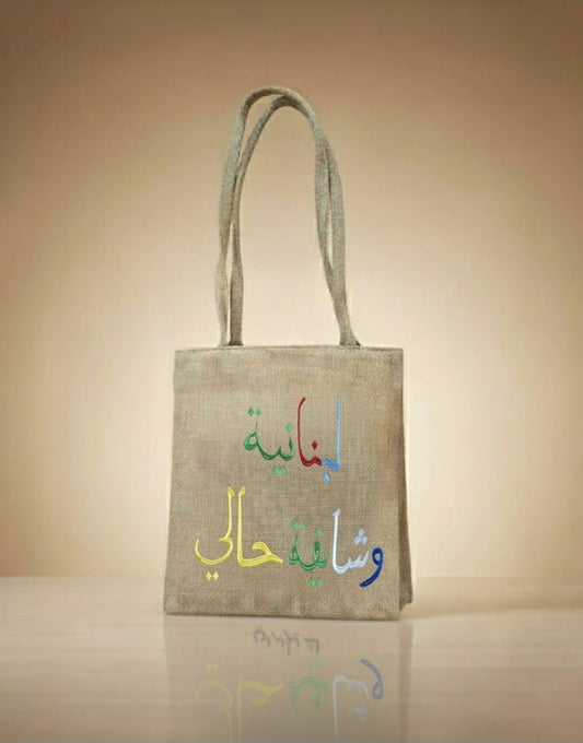 Jute bag with colorful Arabic text on a beige background