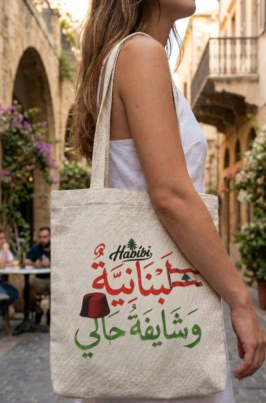 Woman carrying a natural canvas tote bag with Lebanese Arabic calligraphy and cedar tree design