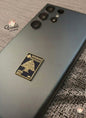 Smartphone with a decorative metal tag on a textured surface