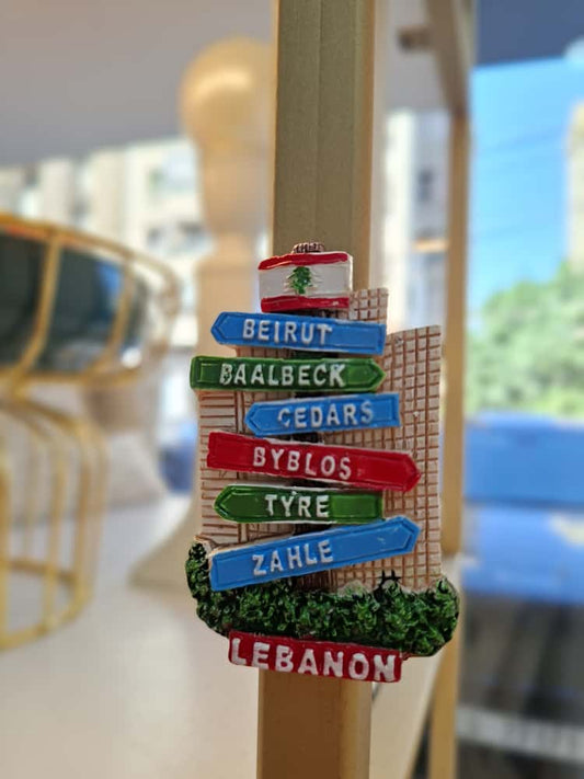Decorative sign with names of Lebanese cities on a stick, blurred background