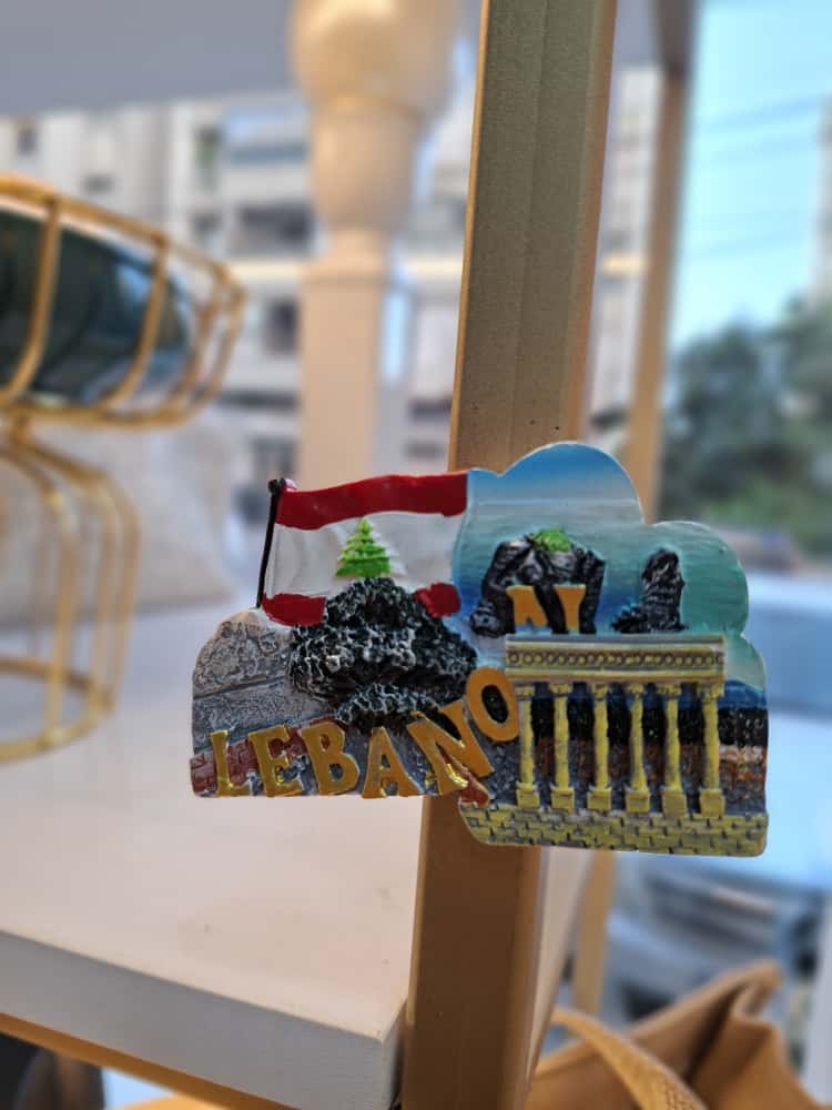 Fridge magnet with Lebanese landmarks and flag on a stand indoors
