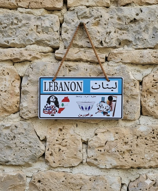Decorative sign with 'LEBANON' text and symbols on a stone wall background