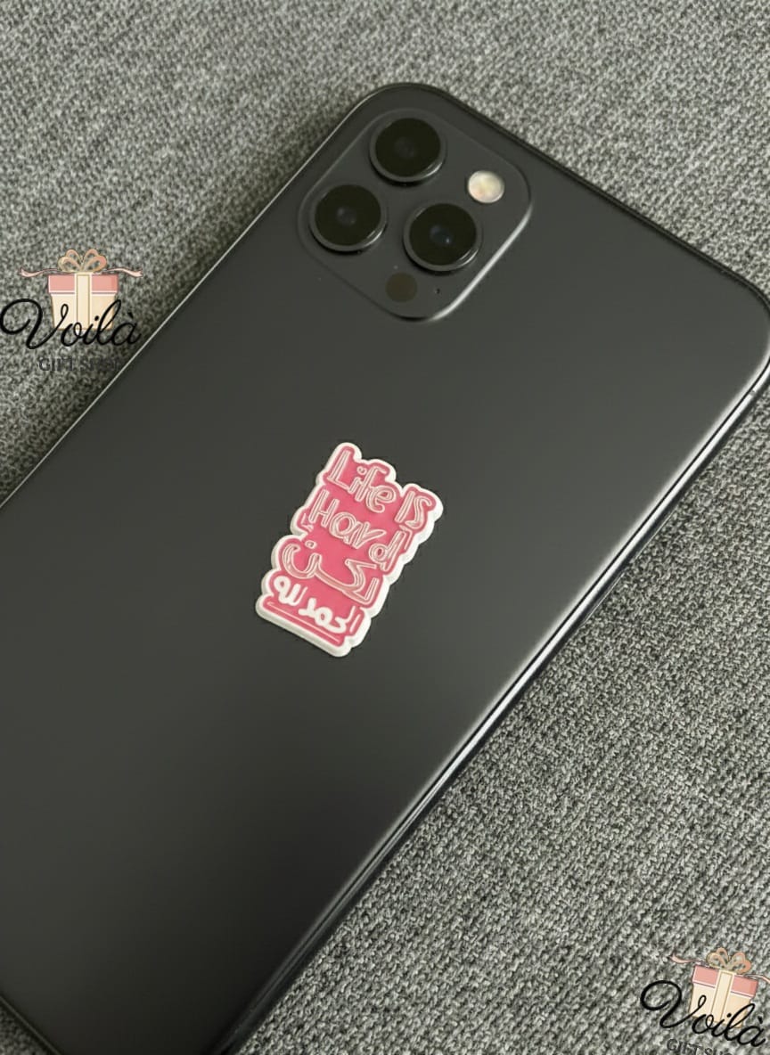 Black smartphone with a pink sticker on a gray textured surface