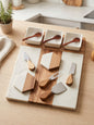 Marble and acacia wood cheese board set with ceramic bowls and cheese tools
