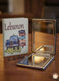 Compact mirror with a case featuring a car illustration and text on a wooden surface