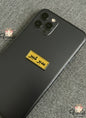Black smartphone with a yellow label on a textured surface, branded 'Voila'.