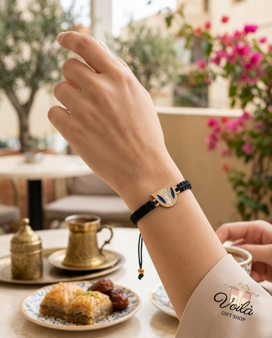 Phoenician heritage gold and blue enamel cord bracelet worn on a wrist in a Lebanese cafe setting