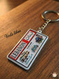 Keychain with 'Voila Liban' branding on a wooden surface
