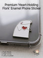 Premium metal Flork enamel phone sticker holding a red heart on a clear phone case.