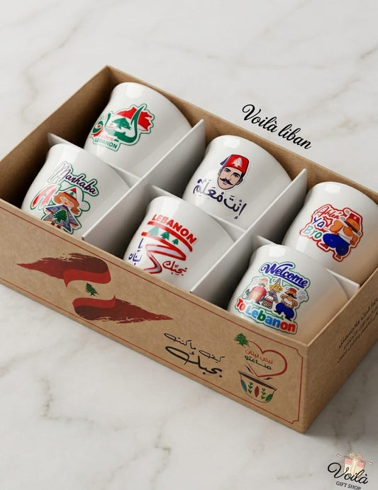 Set of six premium white ceramic Arabic coffee cups featuring colorful Lebanese pop art illustrations, cultural characters, and slang like "Inta M3allem", presented in a beautifully branded kraft display box.