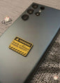 Phone case with a warning label on a textured surface