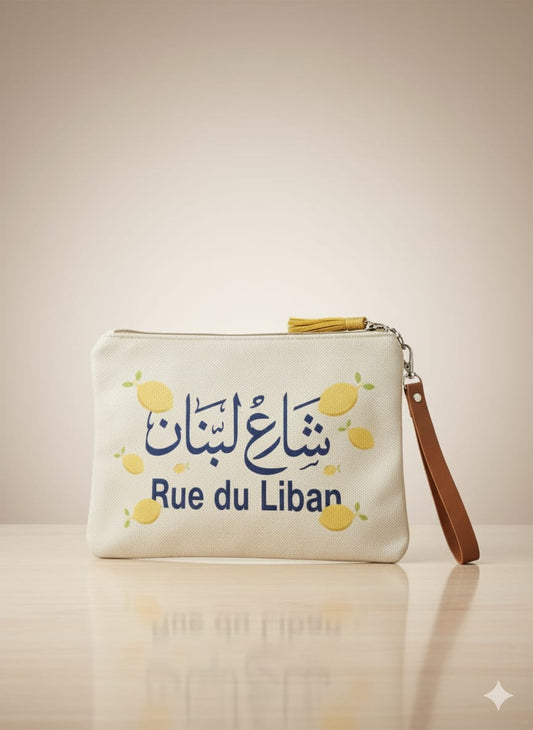 White pouch with 'Rue du Liban' text and lemon illustrations on a beige background
