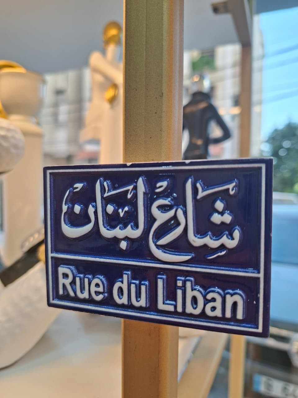 Street sign for 'Rue du Liban' with Arabic text on a blue background