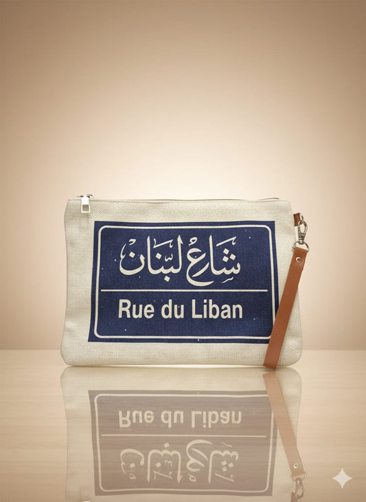 Clutch bag with 'Rue du Liban' label on a reflective surface