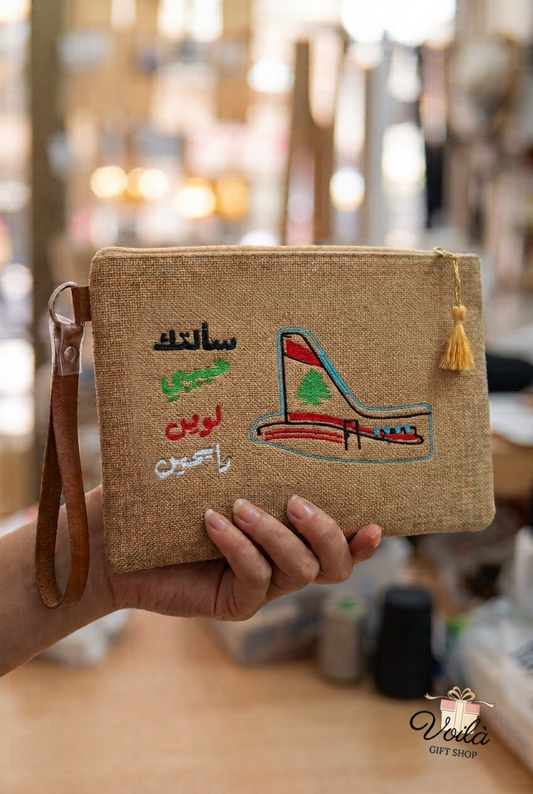 Handmade embroidered jute clutch featuring Fairuz lyrics and MEA cedar tail