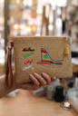 Handmade embroidered jute clutch featuring Fairuz lyrics and MEA cedar tail