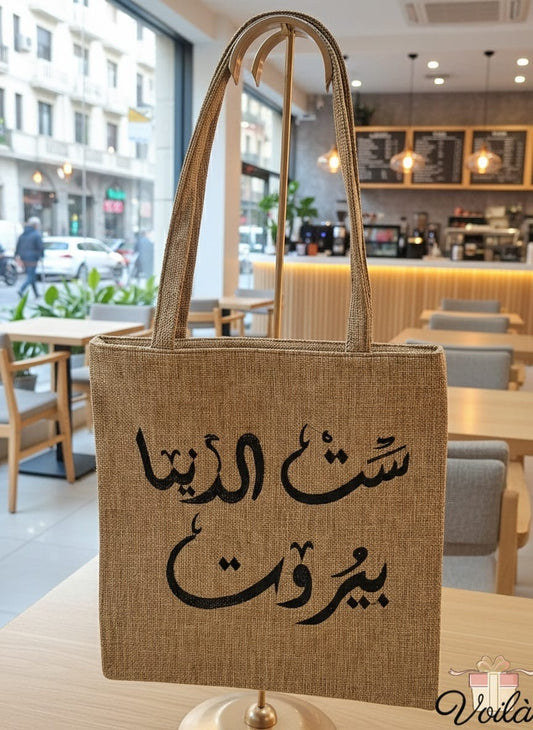 Brown tote bag with Arabic text in a cafe setting