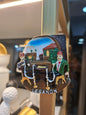 Decorative item with two figures and the word 'Lebanon' on a blurred background