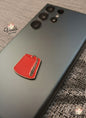 Red tag pin on a phone case with 'Voila' branding.