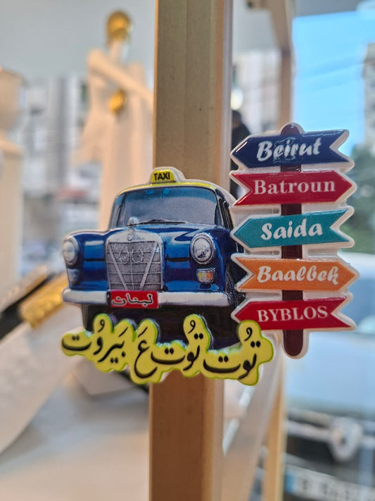Decorative sign with a vintage taxi and city names on a stand.