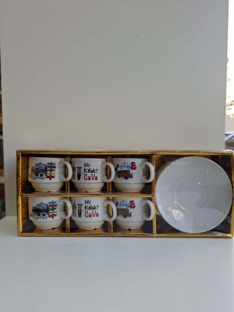 Set of mugs with various designs in a wooden box on a white surface.