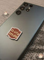 Smartphone with a decorative sticker on a textured surface