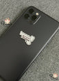 Black phone case with a white sticker on a gray textured background